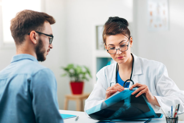 Portrait of Woman Doctor at her Medical Office Looking at X-Ray doctor helps man duringi ntake into california dual diagnosis program